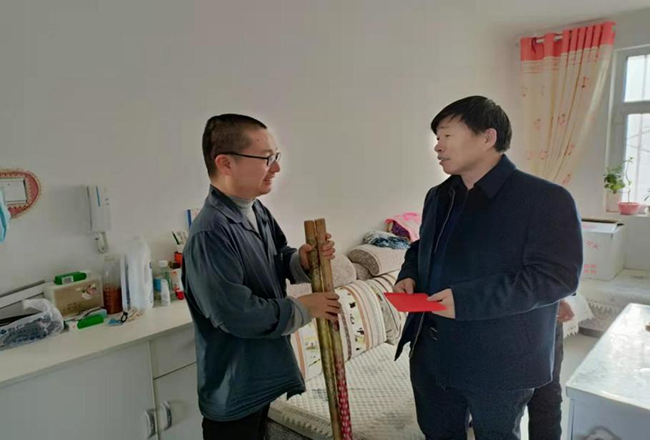 图为王明富一行深入残疾人农户家中进行宣讲并慰问