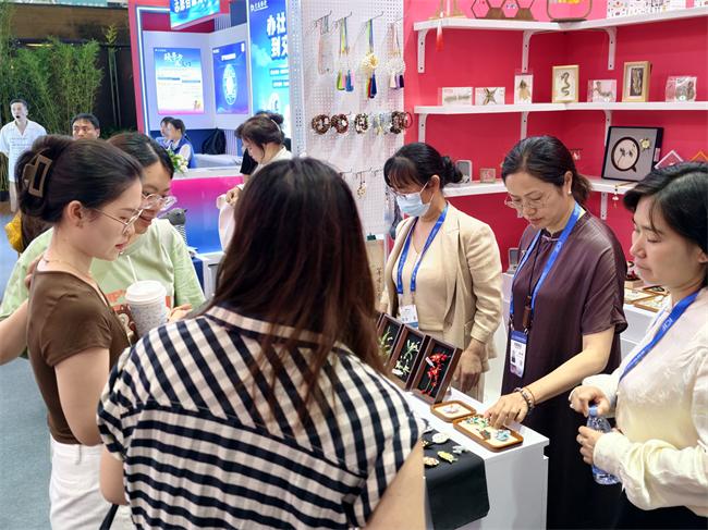 图为众多参展人员被湖南展位展品吸引