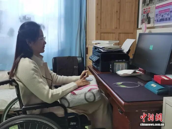 图为坐在电脑前准备写作的康枝英