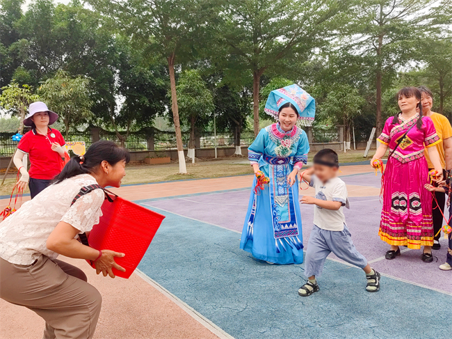 图为家长与幼儿进行抛绣球游戏 图为家长与幼儿进行抛绣球游戏