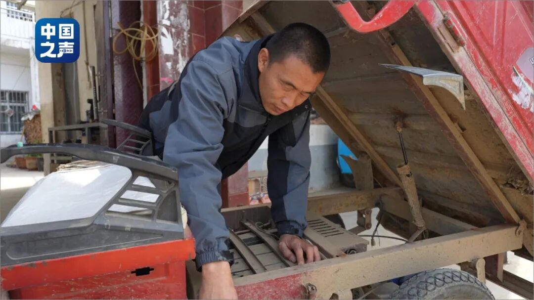 图为李喜柱修电动三轮车