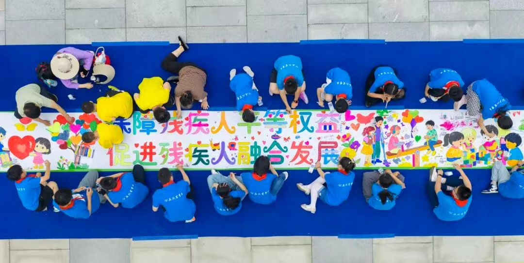 图为淮南市的小朋友们正在主题长卷上作画