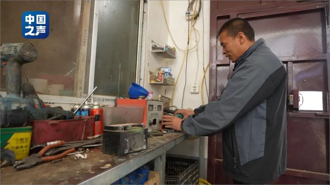 图为李喜柱在整理工作台上的零件